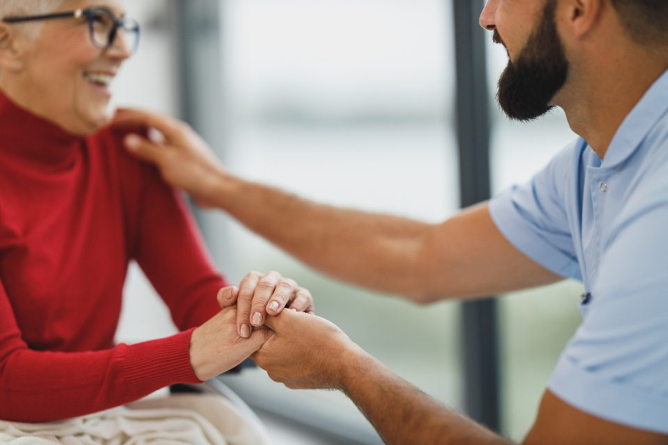 A caregiver holding a resident's hands
